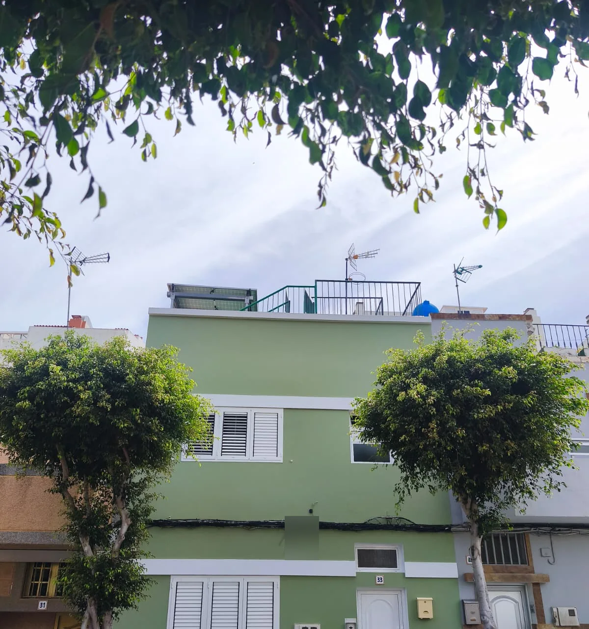 Fachada exterior renovada en verde y blanco