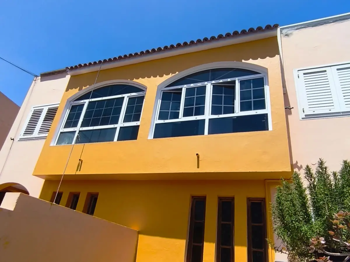 Fachada de vivienda pintada en amarillo por ESS Canarias en Gran Canaria